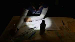 Emily studying sailing charts by head lamp