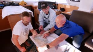 Matt, Capt. Chas, and TIm over some sailing charts