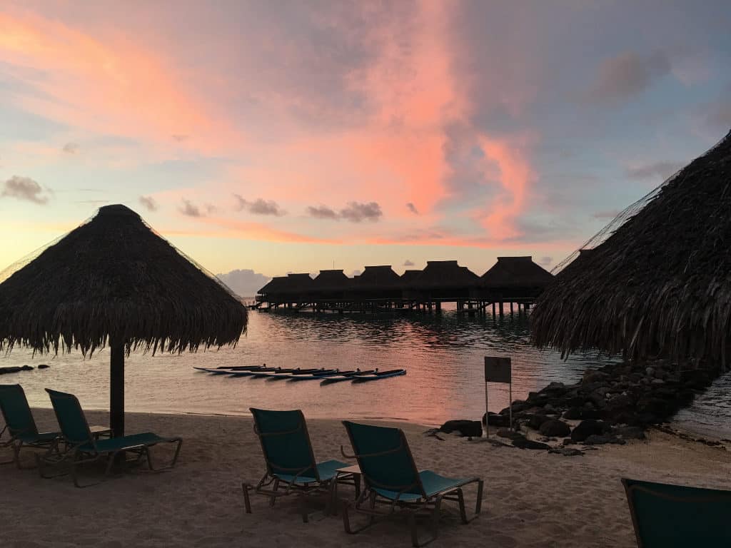 Water bungalows with orange sunset and beach